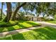 Charming home with lush lawn, mature trees, and manicured landscaping at 2009 Raven Manor Dr, Dover, FL 33527
