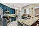 Bright kitchen with navy blue cabinets, granite countertops, and stainless steel appliances at 2009 Raven Manor Dr, Dover, FL 33527