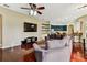 Open-concept living room with dark hardwood floors, a ceiling fan, and a large sectional sofa at 2009 Raven Manor Dr, Dover, FL 33527