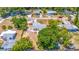 Bird's eye view of a home showcasing the front yard and surrounding trees in the neighborhood at 208 Palmetto W Rd, Nokomis, FL 34275