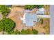 Top-down aerial view showcases the home's layout, yard, and a nearby wooded area at 208 Palmetto W Rd, Nokomis, FL 34275