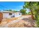 Spacious backyard featuring a well-maintained lawn, mature trees, and the rear exterior of the charming single-story home at 208 Palmetto W Rd, Nokomis, FL 34275