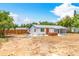 Spacious backyard featuring a well-maintained lawn, mature trees, and the rear exterior of the charming single-story home at 208 Palmetto W Rd, Nokomis, FL 34275