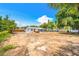 Expansive backyard featuring a well-maintained lawn, privacy fence, and the rear exterior of the charming single-story home at 208 Palmetto W Rd, Nokomis, FL 34275