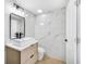 Modern bathroom with sleek vanity, a rectangular sink, and elegant marble tile walls at 208 Palmetto W Rd, Nokomis, FL 34275
