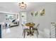 Bright dining area featuring a wood table with metal chairs and leafy wall decor at 208 Palmetto W Rd, Nokomis, FL 34275