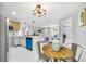 Bright dining room open to kitchen and living room with modern light fixtures at 208 Palmetto W Rd, Nokomis, FL 34275