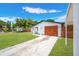 Attractive exterior featuring a long driveway, wooden garage door, and manicured lawn at 208 Palmetto W Rd, Nokomis, FL 34275