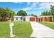 Beautifully landscaped front yard leading to a cozy home with a covered parking area at 208 Palmetto W Rd, Nokomis, FL 34275