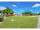 Quaint home showcasing a lush green lawn and convenient covered parking at 208 Palmetto W Rd, Nokomis, FL 34275