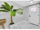 Bright foyer with marble-look tile flooring, indoor plant and a white front door at 208 Palmetto W Rd, Nokomis, FL 34275