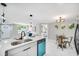 Modern kitchen showcases bright white cabinets, stylish appliances, and a cozy dining area at 208 Palmetto W Rd, Nokomis, FL 34275