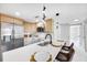Updated kitchen with white cabinets, modern appliances, and a breakfast bar for casual dining at 208 Palmetto W Rd, Nokomis, FL 34275