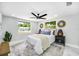 Comfortable bedroom is complete with a ceiling fan and views from the large windows at 208 Palmetto W Rd, Nokomis, FL 34275
