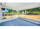 Enclosed patio with blue floors offers view of the expansive backyard at 208 Palmetto W Rd, Nokomis, FL 34275