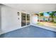 Enclosed patio with blue floors and sliding glass doors offer backyard views at 208 Palmetto W Rd, Nokomis, FL 34275