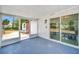 Enclosed patio with blue floors and sliding glass doors offer backyard views at 208 Palmetto W Rd, Nokomis, FL 34275