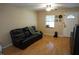 Inviting living room with wood flooring, ceiling fan, and a cozy leather sofa at 2304 W Rio Vista Ave, Tampa, FL 33603