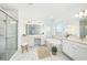 Elegant bathroom with marble tile, a glass shower, and soaking tub, enhanced by stylish decor and natural light at 2492 Overfalls Pl, Wesley Chapel, FL 33543
