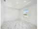 Bright bedroom with marble flooring, recessed lighting and a view of the street at 2492 Overfalls Pl, Wesley Chapel, FL 33543