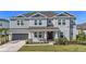 Charming two-story home featuring a manicured lawn, attached garage, and covered entryway at 2492 Overfalls Pl, Wesley Chapel, FL 33543