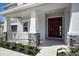 Inviting front porch with stone accents and a craftsman-style front door at 2492 Overfalls Pl, Wesley Chapel, FL 33543