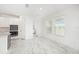 Bright kitchen with white cabinets, marble floors, and views of the laundry room at 2492 Overfalls Pl, Wesley Chapel, FL 33543