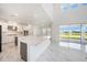 Modern kitchen with stainless steel appliances, marble countertops, and a view of the lake at 2492 Overfalls Pl, Wesley Chapel, FL 33543