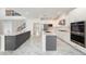 Open kitchen featuring stainless steel appliances, marble countertops, and an open floor plan at 2492 Overfalls Pl, Wesley Chapel, FL 33543