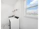 Bright, functional laundry room with modern washer and dryer, convenient shelving, and natural light at 2492 Overfalls Pl, Wesley Chapel, FL 33543