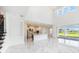 Bright, open-concept living room features soaring ceilings, modern finishes, and a view of the water at 2492 Overfalls Pl, Wesley Chapel, FL 33543
