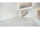 Minimalist living room showcasing high ceilings and marble floors, with a staircase leading to the second floor at 2492 Overfalls Pl, Wesley Chapel, FL 33543