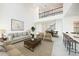 Staged living room featuring high ceilings, marble floors, elegant furnishings, and an open floor plan at 2492 Overfalls Pl, Wesley Chapel, FL 33543