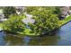Aerial view of a quaint, green, waterfront home with lush trees and a tranquil river at 33 Cypress Dr, Palm Harbor, FL 34684