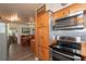 Kitchen with stainless steel appliances and wooden cabinetry, next to the dining area at 33 Cypress Dr, Palm Harbor, FL 34684