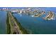 Aerial view of waterfront property featuring lush landscaping, waterfront access, and beautiful blue water at 400 Island Way # 1606, Clearwater Beach, FL 33767