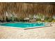 Outdoor community pool area with lounge chairs and shaded seating beneath tiki umbrellas at 400 Island Way # 1606, Clearwater Beach, FL 33767