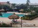Community pool area featuring lounge chairs, umbrellas, and lush tropical landscaping at 400 Island Way # 1606, Clearwater Beach, FL 33767