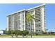 Multi-story condo building featuring balconies and well-maintained landscaping at 400 Island Way # 1606, Clearwater Beach, FL 33767