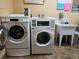 Clean laundry room with multiple washing machines and a utility sink at 400 Island Way # 1606, Clearwater Beach, FL 33767