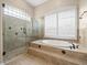 Elegant bathroom with a glass shower, a soaking tub, and tiled accents at 4521 Cheval Blvd, Lutz, FL 33558