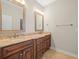 Bathroom featuring double sinks with granite counters and dark wood cabinets at 4521 Cheval Blvd, Lutz, FL 33558