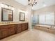 Beautiful bathroom features dual vanities, a walk-in shower, and a luxurious soaking tub at 4521 Cheval Blvd, Lutz, FL 33558