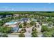 Aerial view of community center with a pool, clubhouse, tennis courts, and beautifully landscaped grounds at 4521 Cheval Blvd, Lutz, FL 33558