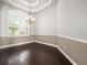 This dining room features chair rails, crown molding, a statement chandelier, and a large window at 4521 Cheval Blvd, Lutz, FL 33558