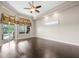 Bright living room boasts hardwood floors, a ceiling fan, and glass sliding doors to the patio at 4521 Cheval Blvd, Lutz, FL 33558