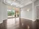 Hardwood floors, a coffered ceiling, sconces and glass sliding doors are found in this comfortable living room at 4521 Cheval Blvd, Lutz, FL 33558