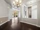 Open-concept living room with dark wood floors, coffered ceiling, columns, and glass doors to the outdoor area at 4521 Cheval Blvd, Lutz, FL 33558