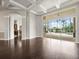 Open concept living room with hardwood floors, a coffered ceiling, and sliding glass doors to the pool at 4521 Cheval Blvd, Lutz, FL 33558