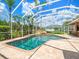 Large screened-in pool surrounded by lush landscaping and featuring a rock waterfall for a private resort feel at 4521 Cheval Blvd, Lutz, FL 33558